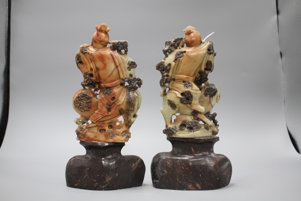 A pair of Chinese soapstone carvings depicting figures riding upon elephants, height 19cm, height with bases 27cm